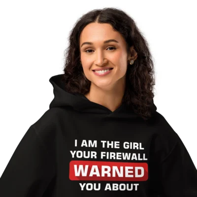 Close-up shot of a black developer hoodie featuring a bold white cybersecurity saying "I'm the girl your firewall warned you about" worn by a female cybersecurity girl model - Premium Funny Developer Hoodies