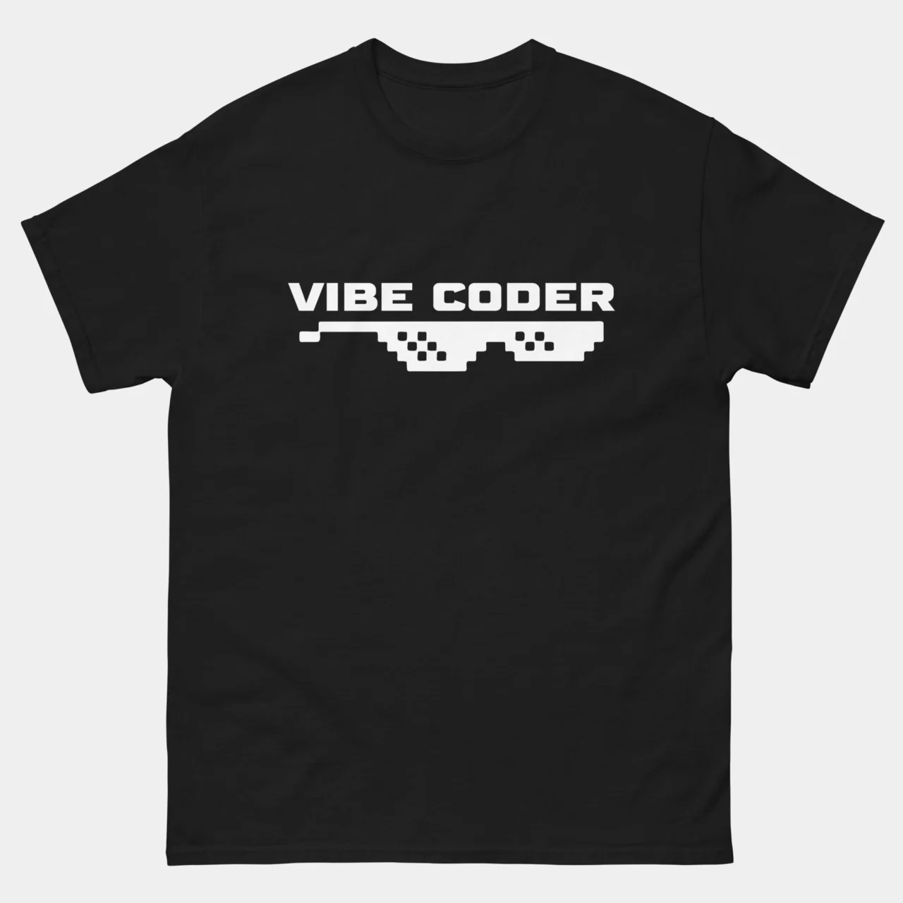 A black Vibe Coder Funny Programmer T-Shirt with white text reading "VIBE CODER" above a pair of white pixelated "Thug Life" style sunglasses. This is a Cool Coding Graphic Shirt