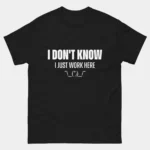 Black sarcastic Funny Office Shirt with bold white text reading I Don't Know I Just Work Here followed by a shruggie ASCII emoticon, funny IT support and helpdesk graphic tee for relatable employees