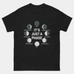 Black It's Just A Phase Funny Moon Astronomy Tee showing all eight lunar phases arranged in a circle with proper labels including New Full Waxing Gibbous and Waning Crescent surrounding bold center text reading It's Just A Phase, science pun graphic tee for moon lovers and astronomy fans